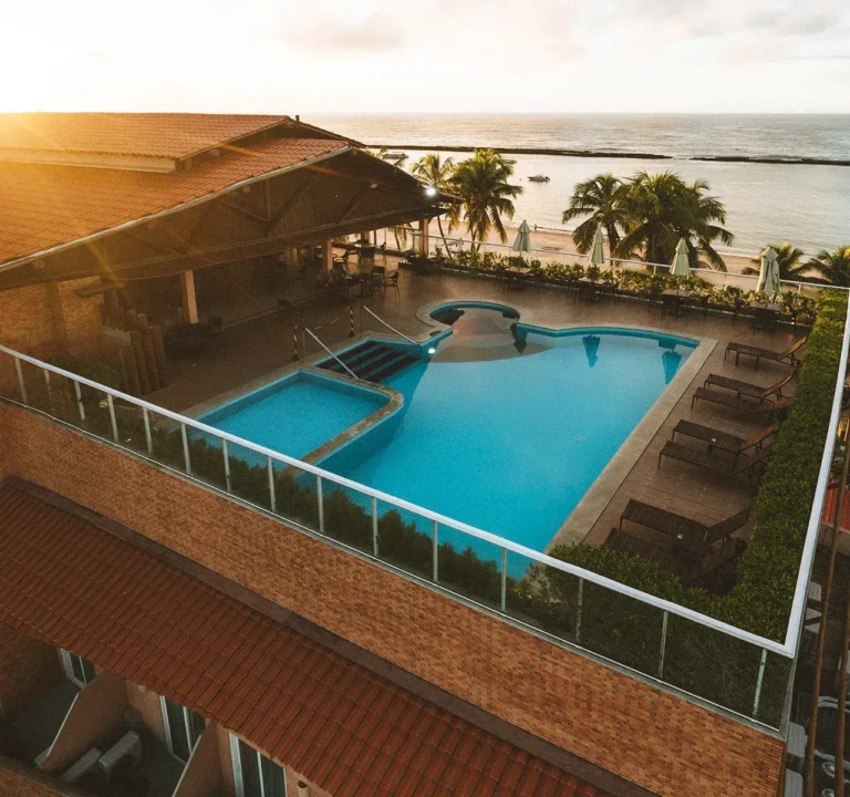 Vista aérea do rooftop do Hotel Ponta Verde Praia do Francês, com a piscina, os coqueiros e o mar do litoral sul de Alagoas