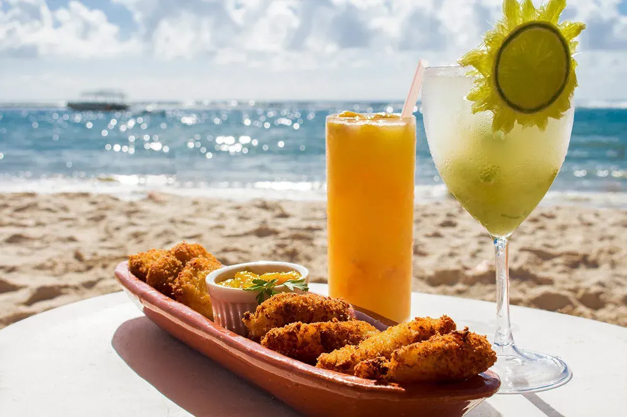 Petiscos e drink servidos na cadeira de praia do hotel, na areia da Praia do Francês