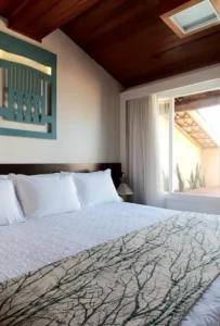 Dormitório da Suíte dos Marechais do Hotel Ponta Verde Praia do Francês, com cama king e teto de madeira