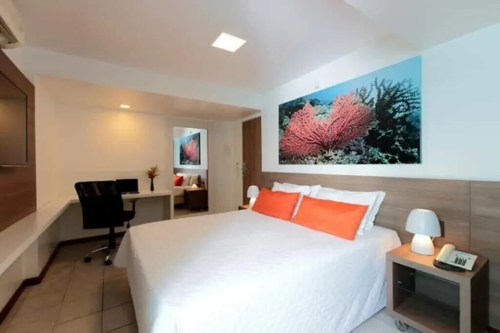 Apartamento Executivo do Hotel Ponta Verde Maceió com cama de casal, mesa de trabalho e cadeira de escritório