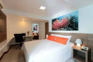 Apartamento Executivo do Hotel Ponta Verde Maceió com cama de casal, mesa de trabalho e cadeira de escritório