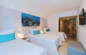Apartamento Lateral Mar Família do Hotel Ponta Verde Maceió com uma cama de casal e duas de solteiro no mesmo ambiente