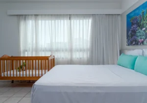 Apartamento Standard Família do Hotel Ponta Verde Maceió com berço montado ao lado da cama