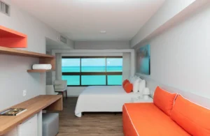 Suíte do Hotel Ponta Verde Maceió com cama queen e janela ampla de frente para o mar